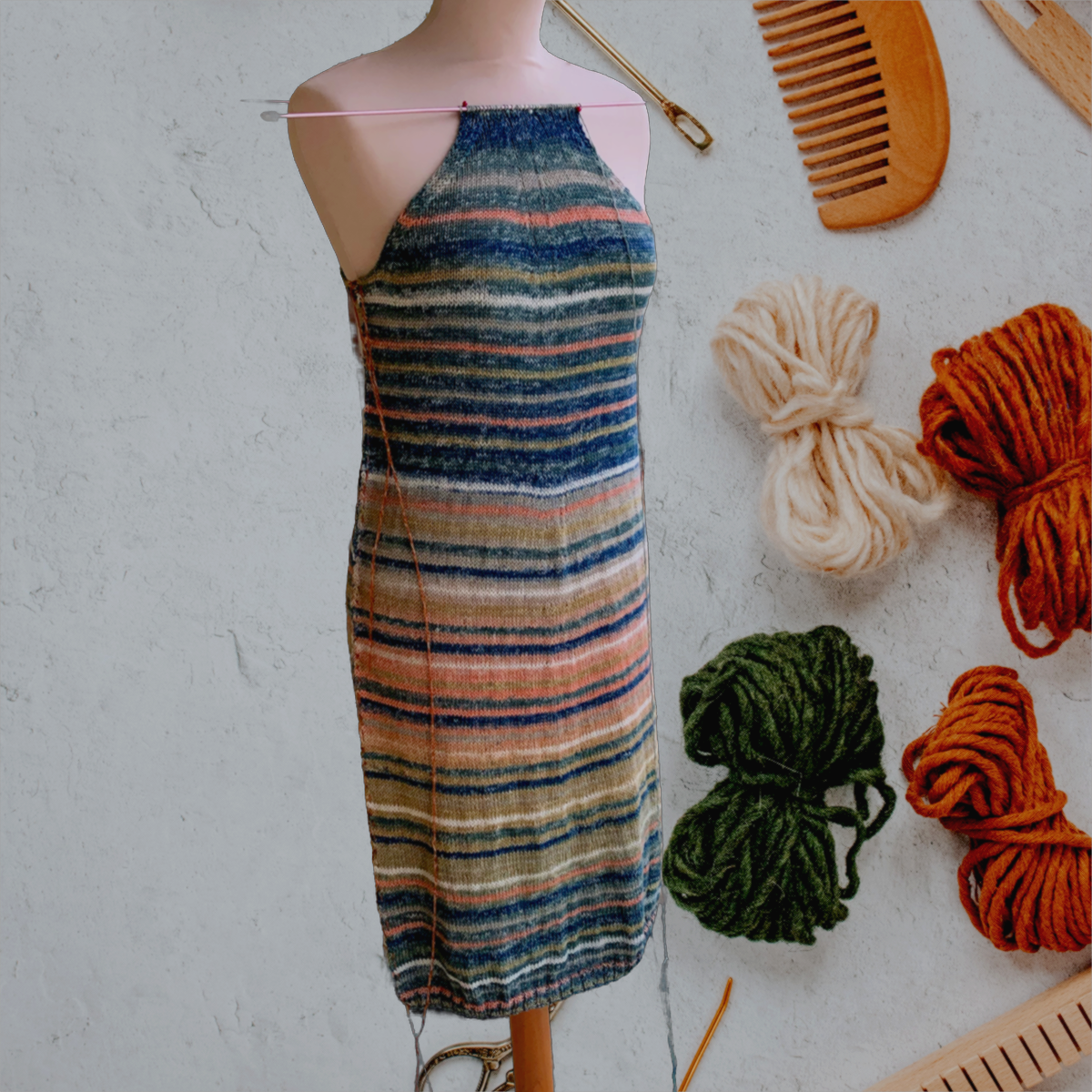 Une robe raglan tricotée main en coton bio multicolore avec des rayures.