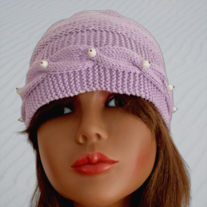 Tricot fait main - Un bonnet en laine lilas avec une bordure torsadée et des perles blanches sur le devant et deux perles sur l'arrière