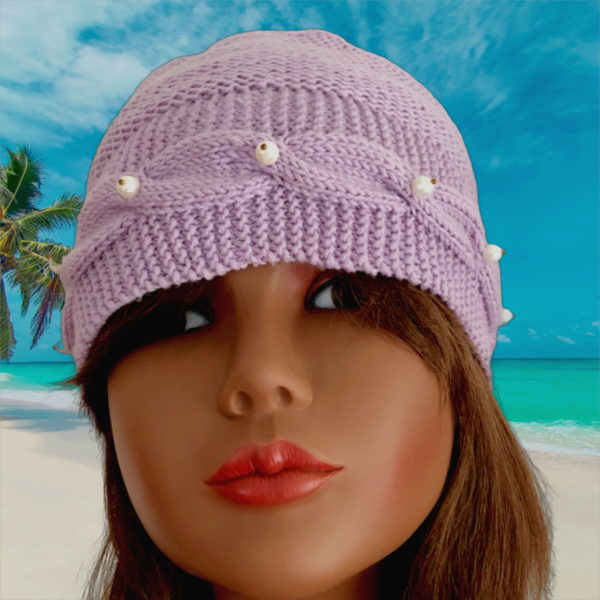 Tricot fait main - Un bonnet en laine lilas avec une bordure torsadée et des perles blanches sur le devant et sur deux boutons sur l'arrière
