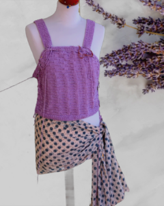  Top court à bretelles tricoté  à la main en Rico Design Luxury Pink Pearl aux motifs divers et orné de 4 perles naturelles.