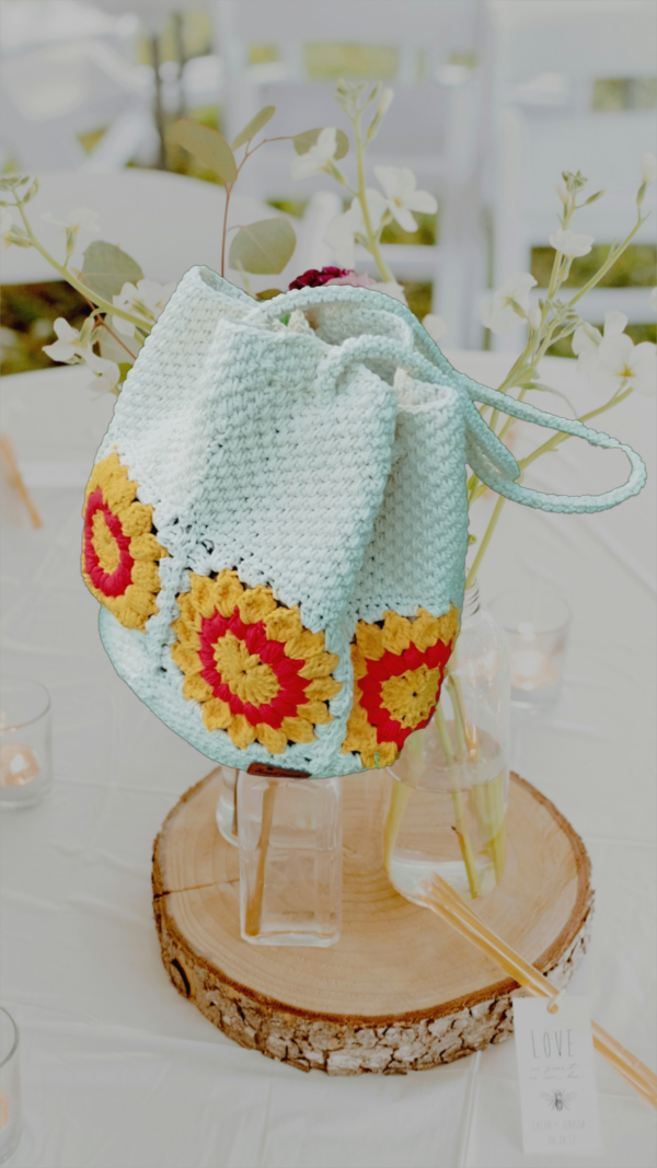 “Sac à main granny éco chic en coton recyclé avec motifs de tournesol rouge et blanc cassé sur une table décorée.”