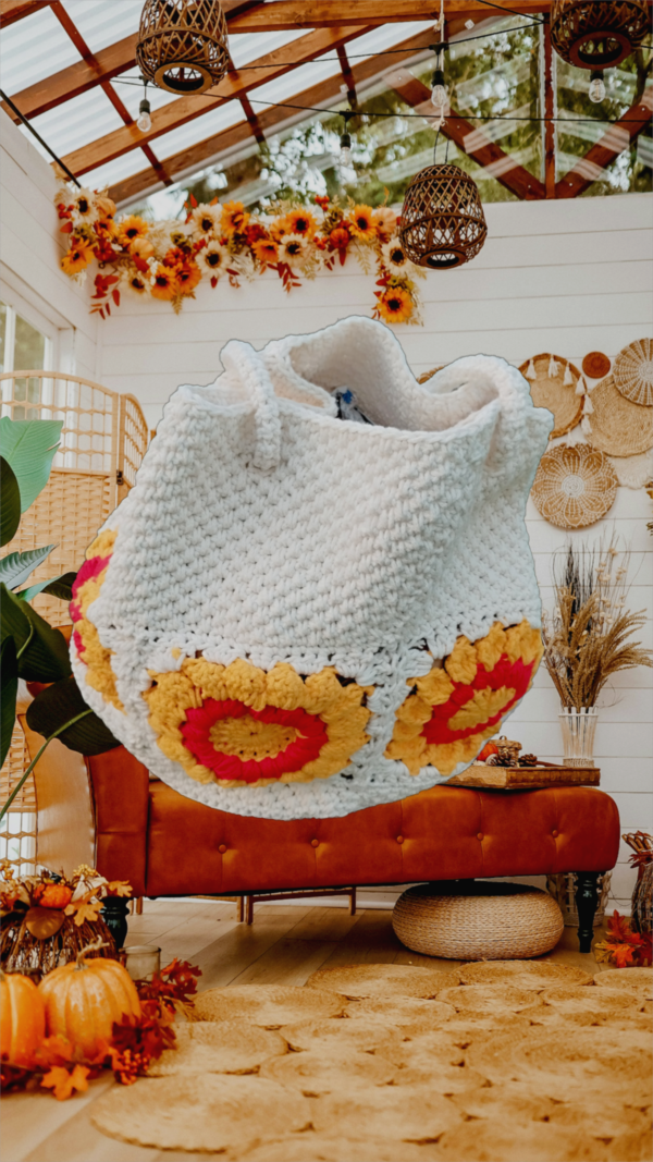 “Sac à main granny éco chic en coton recyclé avec motifs de tournesol rouge et blanc cassé sur une table décorée.”