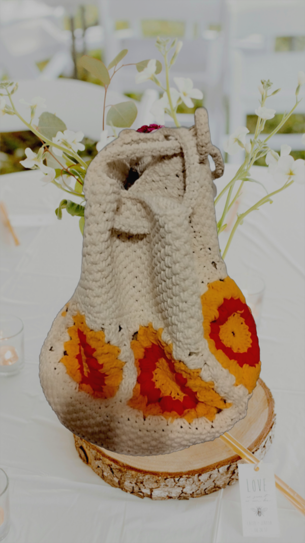 “Sac à main granny éco chic en coton recyclé avec motifs de tournesol rouge et blanc cassé sur une table décorée.”