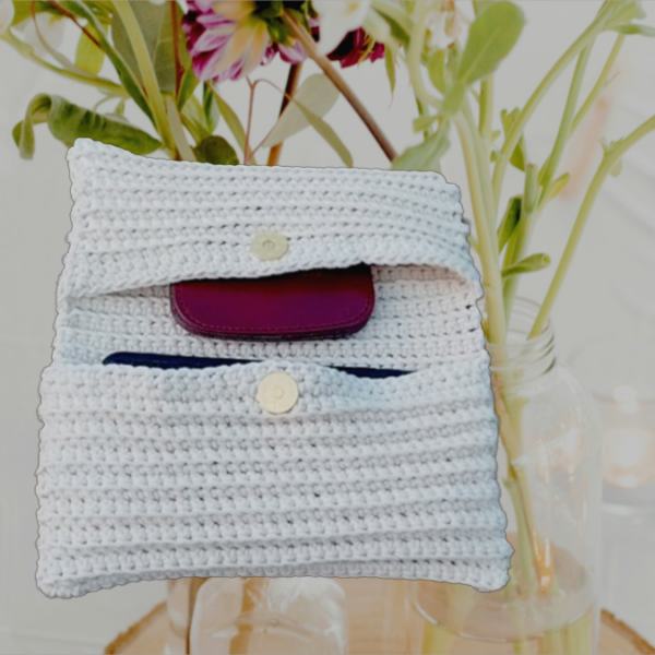 Une pochette élégante en coton recyclé, fait main avec des motifs délicats en blanc cassé