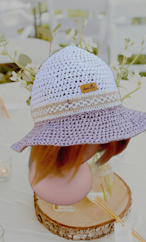 Chapeau enfant en raphia 100 % fibres de bois, bicolore blanc et marron, crocheté main, avec motifs en mailles serrées et mailles serrées brin arrière. Tour de tête 46/48 cm, hauteur 14 cm, largeur 14 cm. Disponible en ligne.