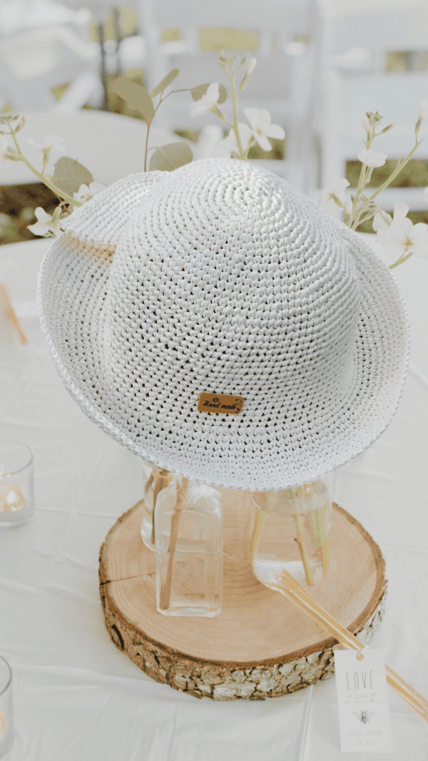 Un chapeau élégant crocheté à la main en raphia 100 % fibres naturelles de bois, idéal pour sublimer vos tenues estivales et apporter une touche glamour en cette période de fête.