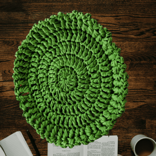 Découvrez l'élégance de notre dessous de verre/sous-tasse rond en raphia anis. Crocheté main avec des brides et une bordure en mailles fantaisie, il apportera une touche naturelle et raffinée à votre table