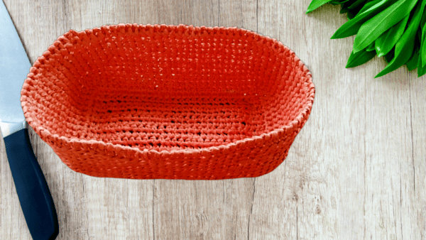 Panier à épices crocheté en raphia saumon, pratique et décoratif.