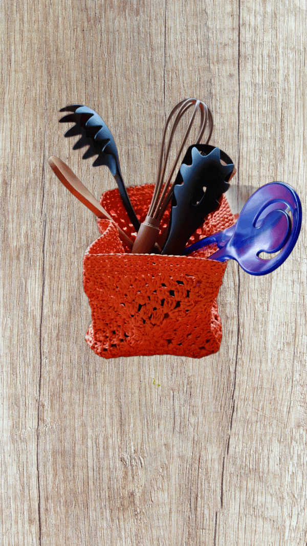 Porte-couverts crocheté en raphia saumon, pratique et chic.