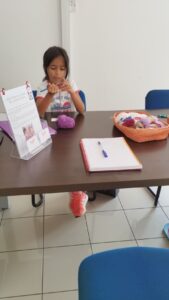 Enfants souriants apprenant le crochet dans une ambiance conviviale.