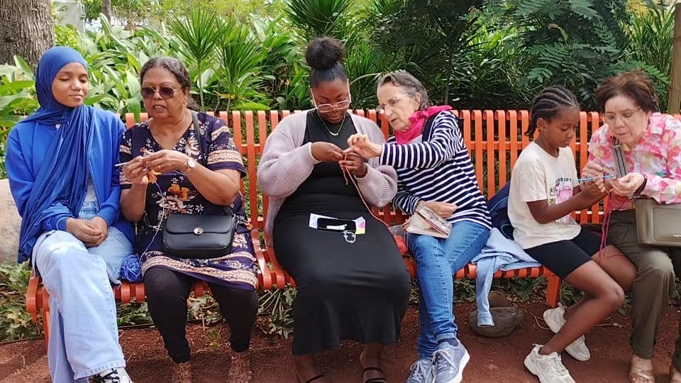 "Atelier crochet en plein air au Jardin de la Liberté : des enfants, des seniors et des adultes engagés, réunis autour d’un moment de création et de partage. Les pompons colorés illuminent l’espace, témoignant de la joie de cette rencontre."
